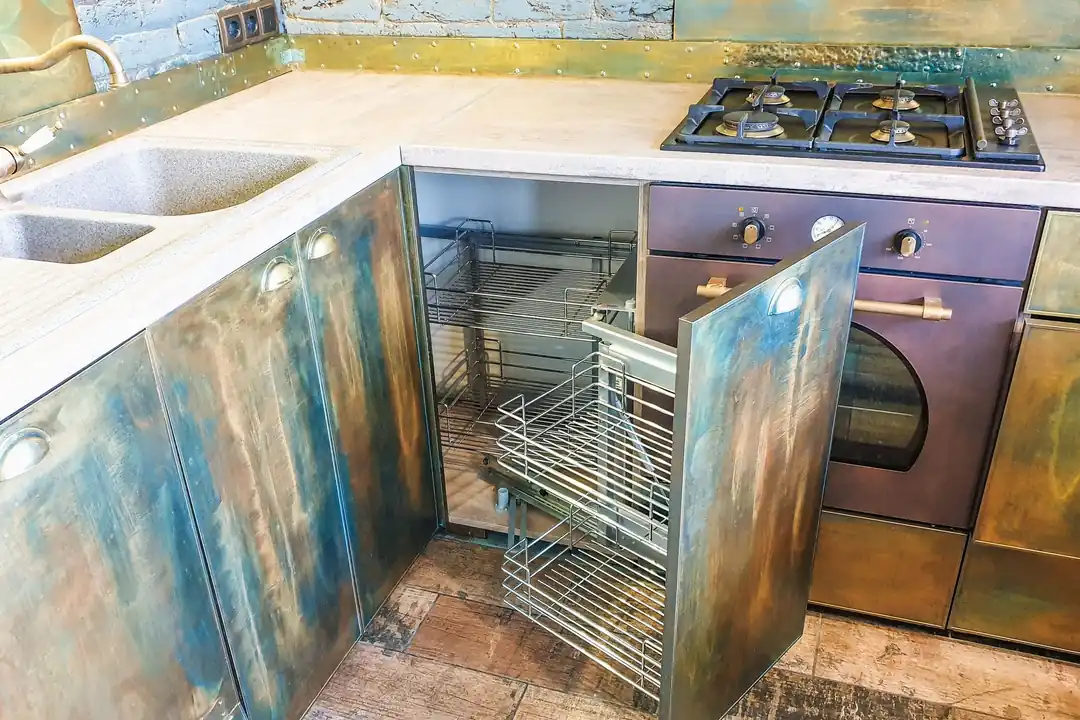 Cocina con placa de gas y horno empotrado, y un mueble esquinero con el cajón extraíble abierto