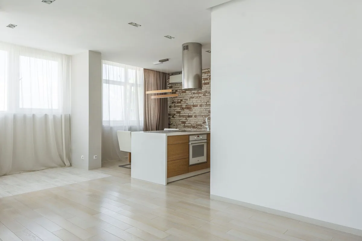 Salón y cocina abierta de una vivienda luminosa, con el horno encastrado en el mueble